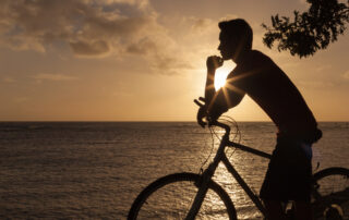 Silhouette of a man with a bike enjoying the sunrise