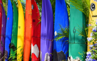 rows of colorful surfboards lined up outside a shop in Maui